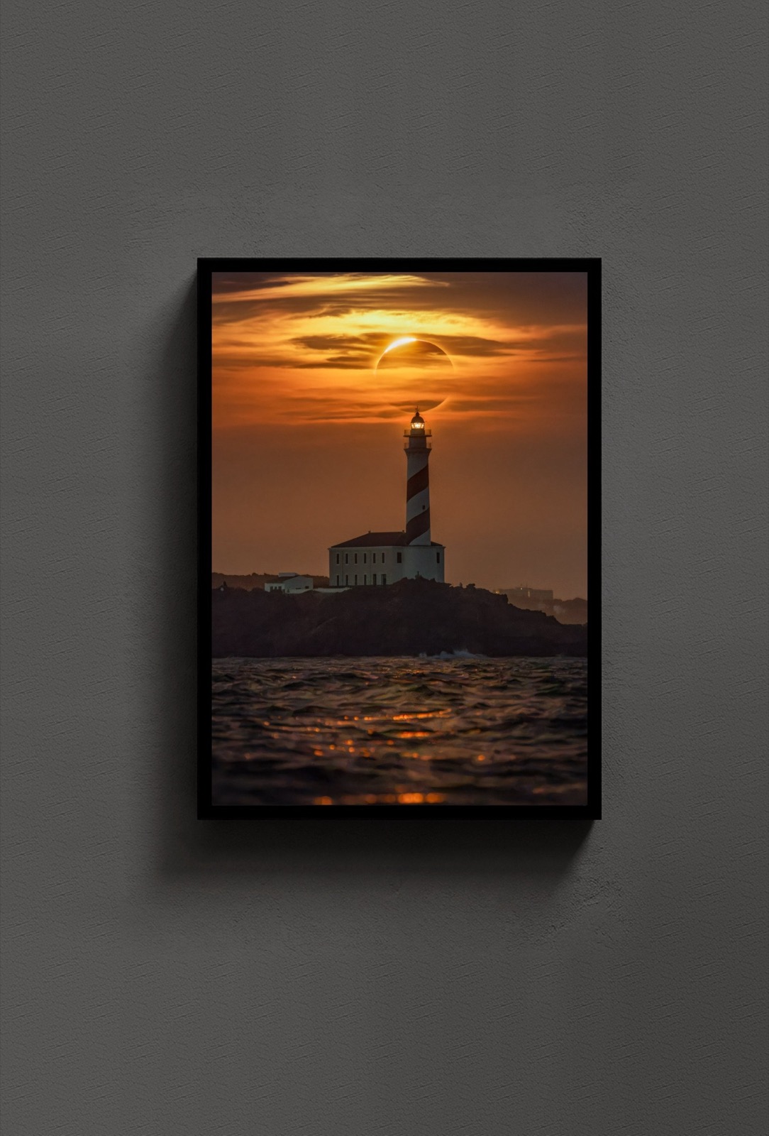 The Lighthouse Eclipse, framed in a black wooden frame on a dark gallery wall